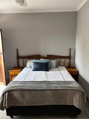 a bedroom with a large bed with blue pillows at Soft Spaces Haven in Pretoria
