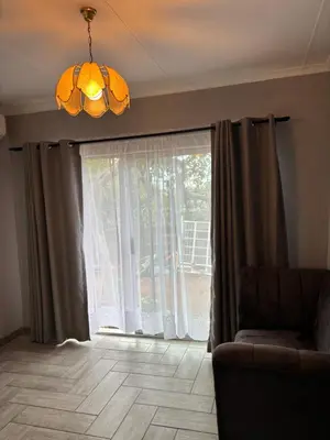 a living room with a couch and a large window at Soft Spaces Haven in Pretoria