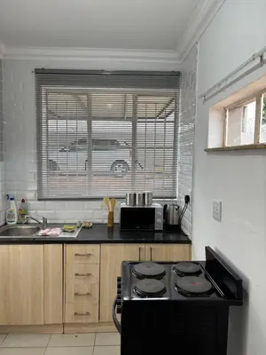 a kitchen with a stove and a sink and a window at Soft Spaces Haven in Pretoria