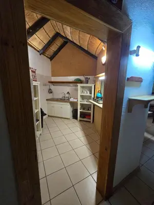 a kitchen with an open door to a room with a counter at The Big Rondawel in Marloth Park