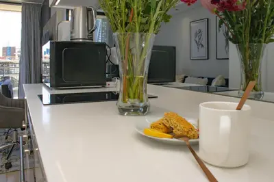 a table with a plate of food and a cup of coffee at Bhonsane Executive Suite, Ellipse, Midrand in Midrand