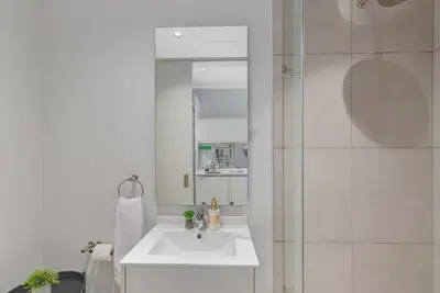 a white bathroom with a sink and a shower at Bhonsane Executive Suite, Ellipse, Midrand in Midrand
