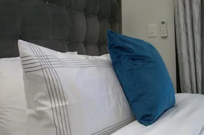 a blue pillow sitting on top of a bed at Bhonsane Executive Suite, Ellipse, Midrand in Midrand