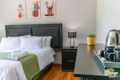 a bedroom with a bed and a table with a camera at The Orange Tree Guest House in Nelspruit