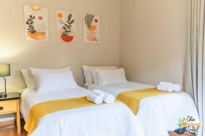 two beds sitting next to each other in a bedroom at The Orange Tree Guest House in Nelspruit