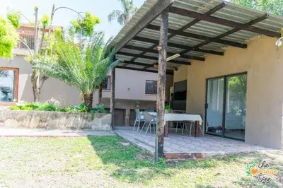 a patio with a table and chairs under a pergola at The Orange Tree Guest House in Nelspruit