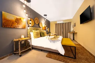 a bedroom with a bed and a tv on the wall at Zabini Lodge and Game Drives in Nelspruit
