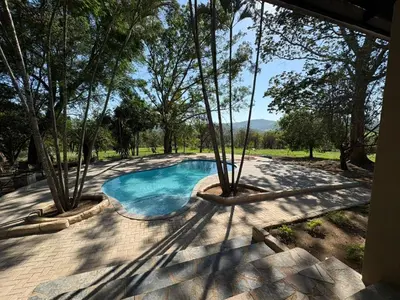 a swimming pool in a yard with trees at Zabini Lodge and Game Drives in Nelspruit