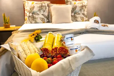 a basket filled with fruit and other food on a bed at Zabini Lodge and Game Drives in Nelspruit