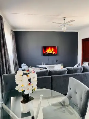 a living room with a couch and a glass table at The Lux apartment in Polokwane