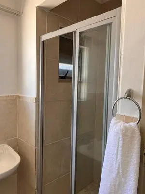 a shower with a glass door in a bathroom at The Lux apartment in Polokwane