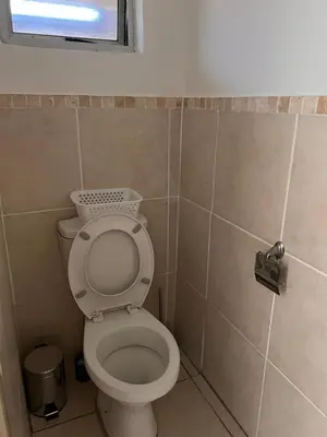 a bathroom with a toilet and a window at The Lux apartment in Polokwane