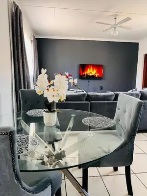 a living room with a glass table and a couch at The Lux apartment in Polokwane