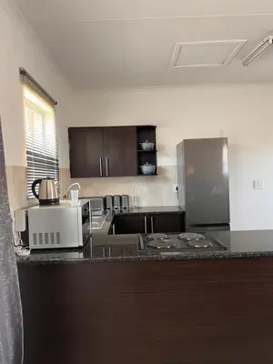 a kitchen with a counter top with a stove at The Lux apartment in Polokwane