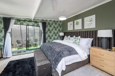 a bedroom with a large bed and a window at Polka Dot Airport Exec Suite in Kempton Park