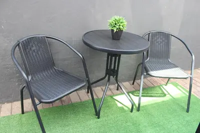 two chairs and a table with a potted plant on it at Polka Dot Airport Exec Suite in Kempton Park