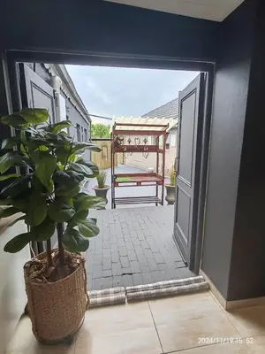 an open door to a patio with a potted plant at Polka Dot Airport Exec Suite in Kempton Park