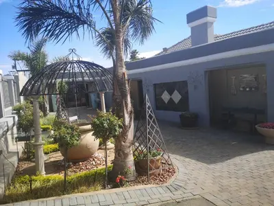 a house with a palm tree and a gazebo at Polka Dot Airport Exec Suite in Kempton Park