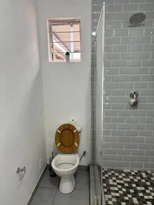a bathroom with a toilet with a wooden seat at Hideaway Haven in Pretoria