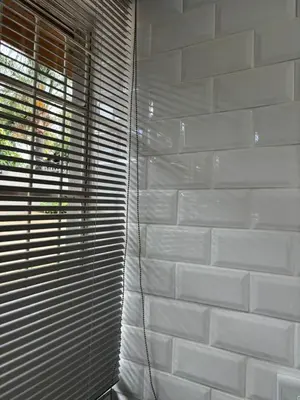 a white brick wall with blinds on a window at Hideaway Haven in Pretoria