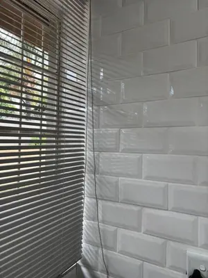 a white brick wall with blinds on a window at Hideaway Haven in Pretoria