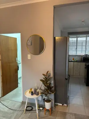 a room with a table and a mirror on the wall at Hideaway Haven in Pretoria