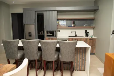 a kitchen with a table and chairs in a kitchen at The Solis Aparthotel in Mzinti