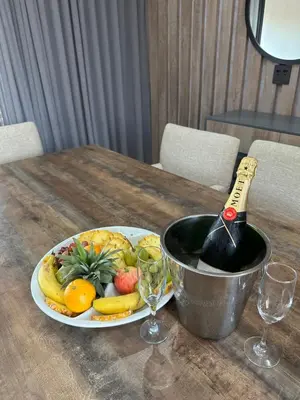 a bottle of wine on a table with a plate of fruit at The Solis Aparthotel in Mzinti