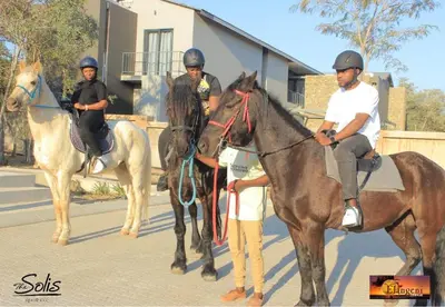 a group of people riding on horses in the street at The Solis Aparthotel in Mzinti