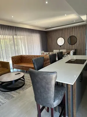 a living room with a table and chairs and a couch at The Solis Aparthotel in Mzinti