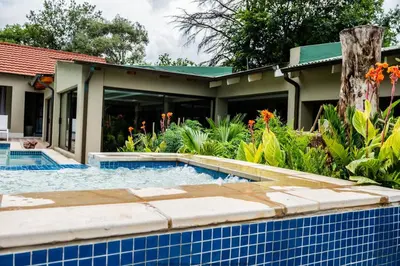 a swimming pool in front of a house at The Fine Line Lodge in Pretoria