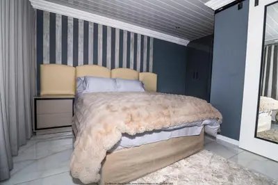 a bedroom with a large bed with a large blanket at The Fine Line Lodge in Pretoria