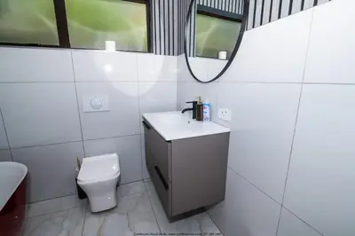 a bathroom with a toilet and a sink and a mirror at The Fine Line Lodge in Pretoria