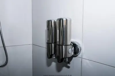 a towel dispenser on a wall in a bathroom at The Fine Line Lodge in Pretoria