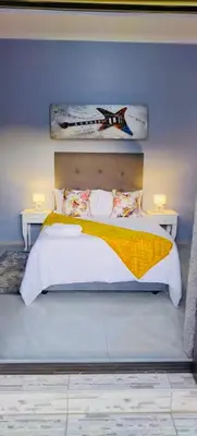 a bedroom with a large bed with two night stands at Morodi Guest Lodge in Witbank
