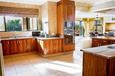 a large kitchen with wooden cabinets and appliances at Zebula 6 Bedroom Lodge IV2 in Warmbaths