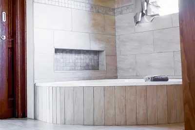 a bathroom with a bath tub with a window at Zebula 6 Bedroom Lodge IV2 in Warmbaths