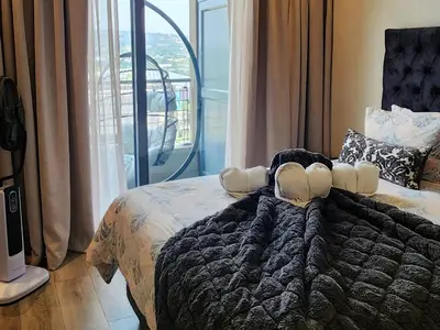 a bedroom with a bed with a large window at Menlyn Maine Apartment with Sunbet Casino view in Pretoria
