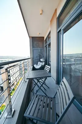 a balcony with two benches and a swing at Menlyn Maine Apartment with Sunbet Casino view in Pretoria