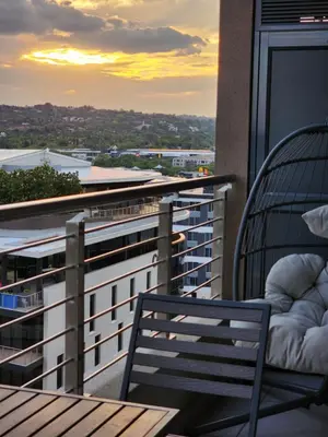 a balcony with a chair and a view of a city at Menlyn Maine Apartment with Sunbet Casino view in Pretoria