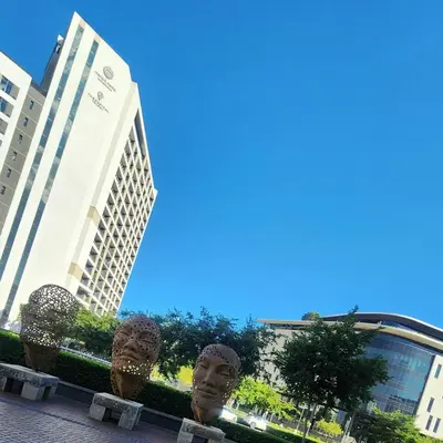 a pair of head statues in front of buildings at Menlyn Maine Apartment with Sunbet Casino view in Pretoria