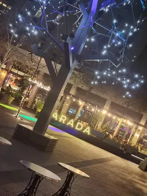 two benches in front of a building with lights at Menlyn Maine Apartment with Sunbet Casino view in Pretoria