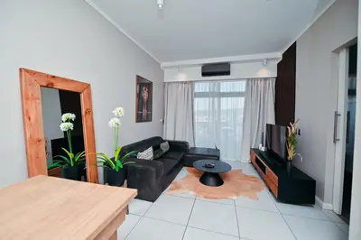 a living room with a couch and a television at Menlyn Maine Apartment with Sunbet Casino view in Pretoria