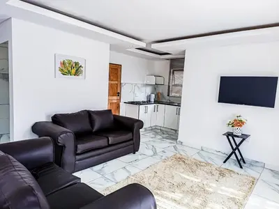 a living room with a couch and a tv at Eden Groove Luxury self catering Guesthouse in Matsulu