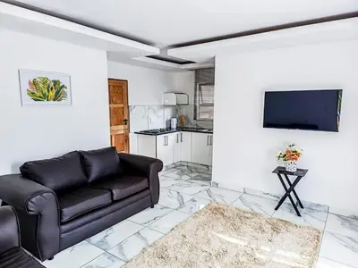 a living room with a couch and a tv at Eden Groove Luxury self catering Guesthouse in Matsulu