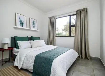 a bedroom with a large bed and a window at Tranquil Willows in Pretoria