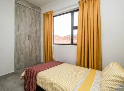 a bedroom with a bed and a window at Tranquil Willows in Pretoria
