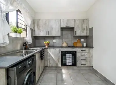 a kitchen with a sink and a dishwasher at Tranquil Willows in Pretoria