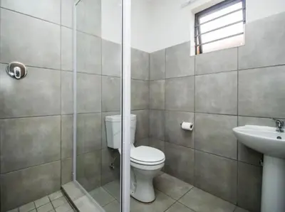 a bathroom with a toilet and a sink and a shower at Tranquil Willows in Pretoria