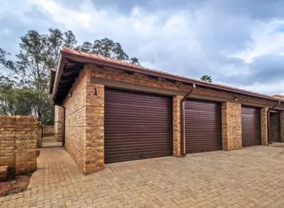 a brick garage with two garage doors on it at Tranquil Willows in Pretoria